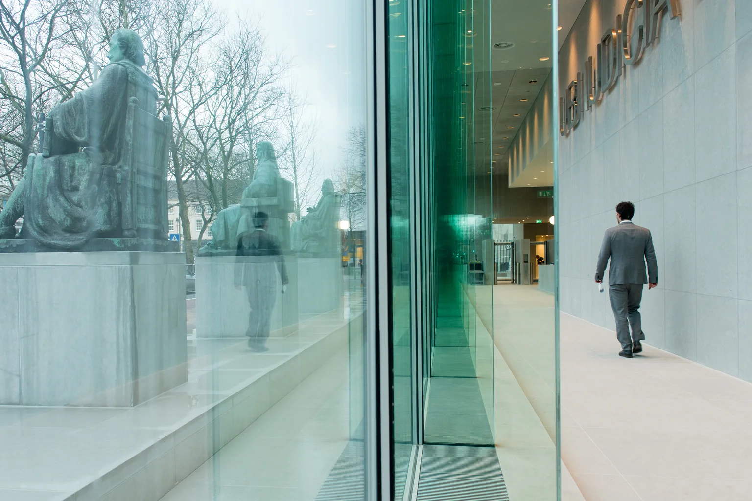 Interieur van de Hoge Raad in Den Haag, met zicht op de beelden langs de glazen gevel. Foto: Bas Kijzers / Rijksvastgoedbedrijf.